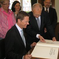 Oberbürgermeister präsentiert Guido Westerwelle das Goldene Buch der Stadt.