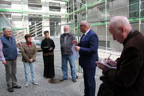 OB Schilder ist mit mehreren Personen zu sehen. Er erläutert die Sanierung.