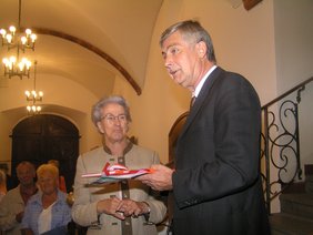 Thea Zimmer überreicht Bürgermeister Hans Ferk das Gastgeschenk