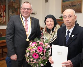 Oberbürgermeister Schilder hat dem Jubilar Mehmet Yildirim die Auszeichnung und seiner Ehefrau Devlet Yildirim einen Blumenstrauß überreicht.