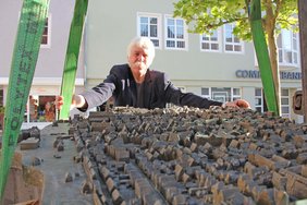 Zu sehen ist der Künstler und vor ihm das Modell, das noch in den Seilen am Tieflader hängt.