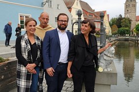 Die vier Personen stehen neben der Katzen-Skulptur