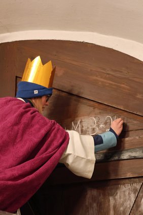 Das C+M+B wird mit Kreide an das Tor geschrieben.