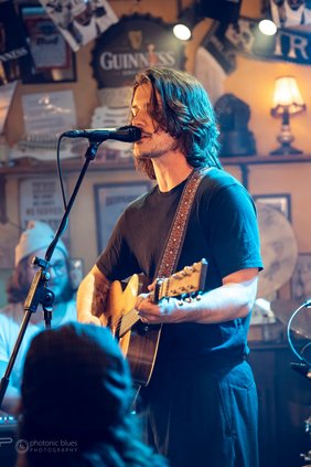 Mann mit Gitarre, singend