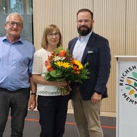 Ehepaar Seitz mit OB, Frau Seitz hält einen Blumenstrauß.