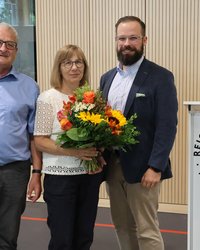 Ehepaar Seitz mit OB, Frau Seitz hält einen Blumenstrauß.