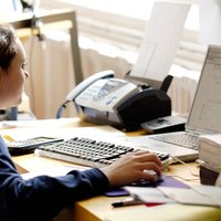 Eine Schülerin sitzt am Schreibtisch vor einem Computer.