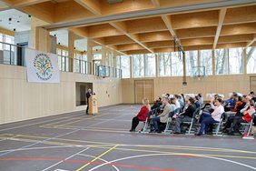 Ein Redner und in der Mitte der Halle rund 70 Stühle in Reihen. Rundherum viel Platz in der Turnhalle.