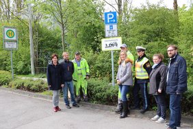 Ein Schild mit dem Text "Elternhaltestelle - ab hier schaffen wir es alleine" wurde enthüllt, alle Personen stehen beidseitig neben dem Schild.