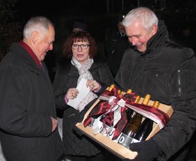 Rathausmitarbeiter Dieter Klotz und Bürgermeisterin Margareta überreichen dem Jubilar Bernhard Feil ein Weinpräsent.
