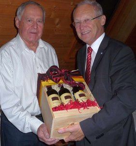 OB Dr. Holzinger übereicht einen Karton mit mehreren Flaschen Rotwein an Bernd Feil