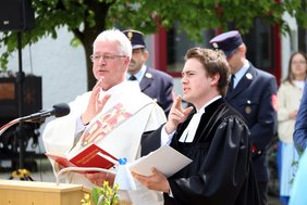 Die Geistlichen in Ornat heben jeweils die Hand zum Segen