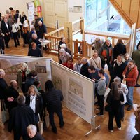 Blick von oben auf viele Menschen, die an Ständen oder Messetafeln stehen, im Gespräch miteinander sind oder zum nächsten Stand weitergehen