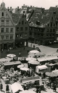 Historische Aufnahme: Blick vom Rathaus über den Marktplatz auf dem gerade der Wochenmarkt stattfindet.