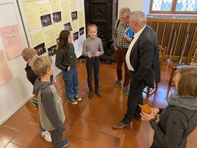 Kinder im Gespräch mit OB Schilder. Im Hintergrund Schautafeln.