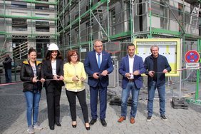 Die Gruppe ist dabei, ein Band zu zerschneiden als symbolischer Auftakt zur Sanierung