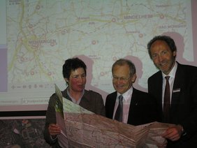 Mechthild Feldmeier, Oberbürgermeister Dr. Ivo Holzinger und Landrat Hans-Joachim Weirather studieren die neue Radfahrkarte.