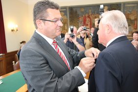 Staatssekretär Pschierer steckt Friedrich Brey den Orden an