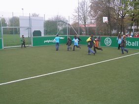 Fußballspielende Kinder auf dem Spielfeld.