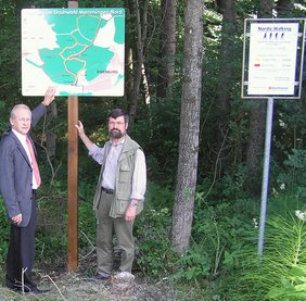 Das Bild zeigt Oberbürgermeister Dr. Ivo Holzinger  und den Leiter des Städtischen Forstamtes, Georg Jutz, bei der Vorstellung der neuen Beschilderung im Eisenburger Wald.
