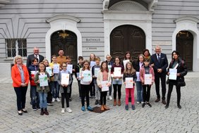 Die Gruppe steht vor der Rathaus-Fassade.