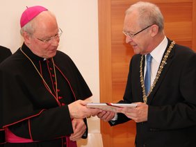 Der Oberbürgermeister überreicht ein Stadtbuch