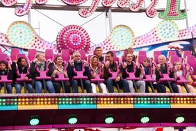 Sitzreihen mit fest angeschnallten Mitfahrenden sind von unten zu sehen.