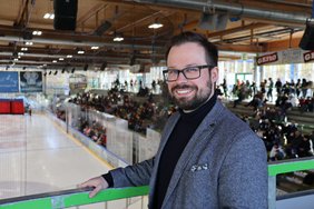 OB in der Eishalle, im Hintergrund ist die Eisfläche und ein Teil des Zuschauerraums
