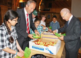 Landrat Hans-Joachim Weirather und Oberbürgermeister Dr. Ivo Holzinger helfen beim befüllen der Brotzeitdosen