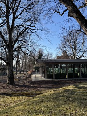 Vom Park aus sieht man nur die ebenerdige Glasfassade. Das Gebäude ist gar nicht hoch und fügt sich gut in die Umgebung des Parks ein. Der Park ist auch nicht eben, sondern hat paar Hügel rund um die Halle. 