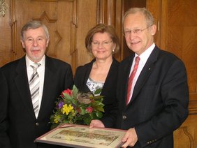 Der langjährige Wirt des „Engelkellers“ Lothar Jende (links) erhielt von Oberbürgermeister Dr. Holzinger (rechts) den Wechterstich der Stadt Memmingen verliehen. Mit Blumen bedankte sich das Stadtoberhaupt bei Ehefrau Paula.
