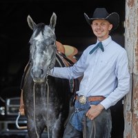 Ein Mann mit Cowboyhut und Pferd.