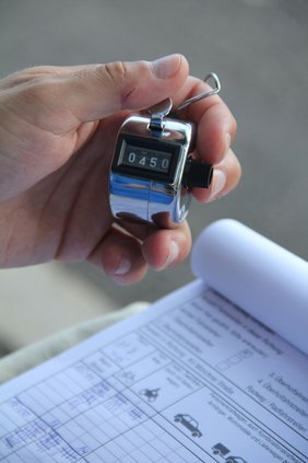 Eine Detailaufnahme: Man sieht eine Hand, die ein Zählgerät hält.