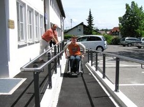 Claus Turnwald im Rollstuhl auf der Rampe mit Walter Plail, dem Leiter des Straßenverkehrsamtes.