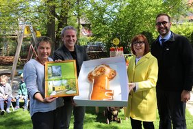 Die Gruppe hält einen großen Schlüssel aus Hefegebäck in Händen.