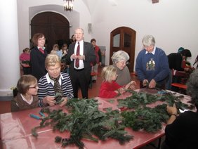 Kinder beim Adventskranz binden