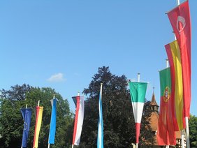 Die Fahnen von Europa, Deutschland, Bayern, der Stadt Memmingen, der Türkei, Griechenland, Spanien, Portugal und Italien wehen im Wind.