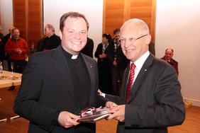 Beim Stehempfang im Pfarrsaal von St. Josef überreicht Oberbürgermeister Dr. Ivo Holzinger Dekan Waldmüller das Theaterbuch