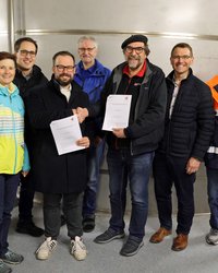 Gruppe vor hohem Edelstahl-Wasserbehälter