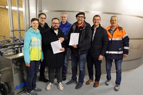 Gruppe vor hohem Edelstahl-Wasserbehälter