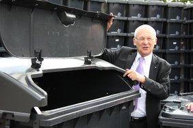 Oberbürgermeister Dr. Holzinger demonstriert, wie leicht der Deckel der neuen 1 100-Liter-Tonne zu öffnen ist.