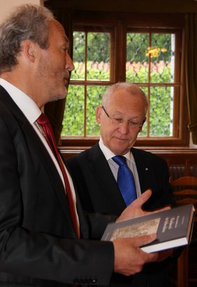 Präsident Weirather überreicht OB Dr. Holzinger ein Buch