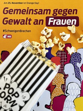 Auf einem Plakat liegt eine Popcorntüte, das Popcorn ist ausgestreut. Text auf dem Plakat: Am 25. November ist Orange Day! Gemeinsam gegen Gewalt an Frauen #SchweigenBrechen