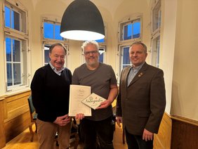 Zu sehen sind die genannten Personen in einem Raum im Memminger Rathaus.