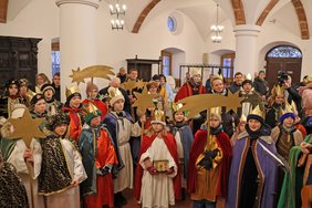 Viele Mädchen und Buben mit prächtigen Gewändern.