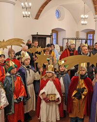 Viele Mädchen und Buben mit prächtigen Gewändern.