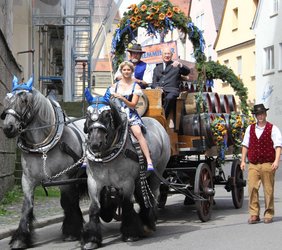 Oberbürgermeister Dr. Holzinger fährt auf dem Kutschbock des Brauereigespanns auf den Marktplatz ein. Auf einem der belgischen Kaltblüter: Bierkönigin Angelina