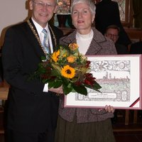 Oberbürgermeister Dr. Holzinger übergibt Leipert Blumen und einen Stich der Stadt