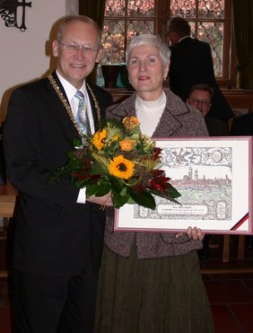 Oberbürgermeister Dr. Holzinger übergibt Leipert Blumen und einen Stich der Stadt