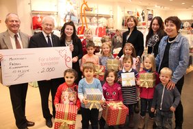 Gruppenbild von der Scheckübergabe in der Kinderabteilung der C&A-Filiale in Memmingen